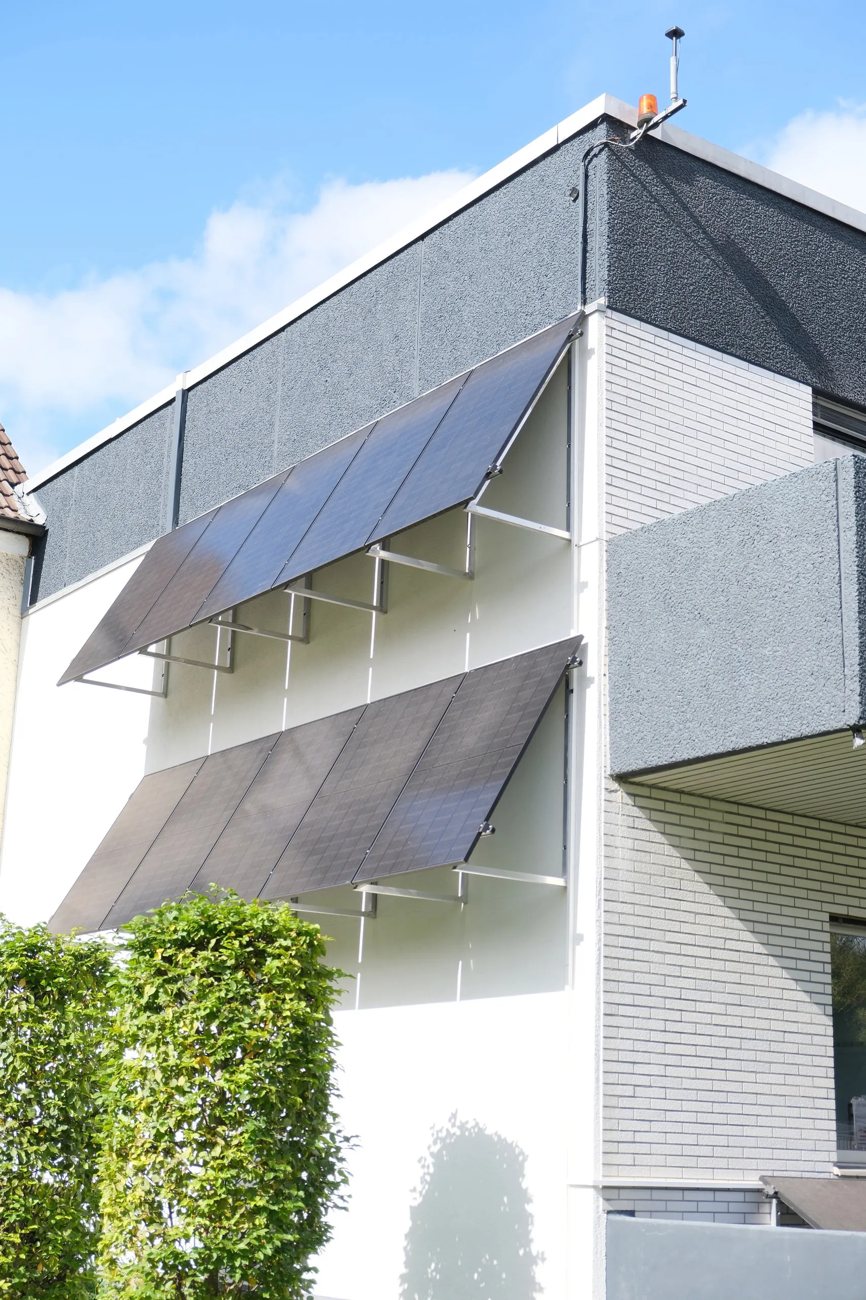 Zwei Reihen Photovoltaikmodule als Verschattung an einer Hausfassade