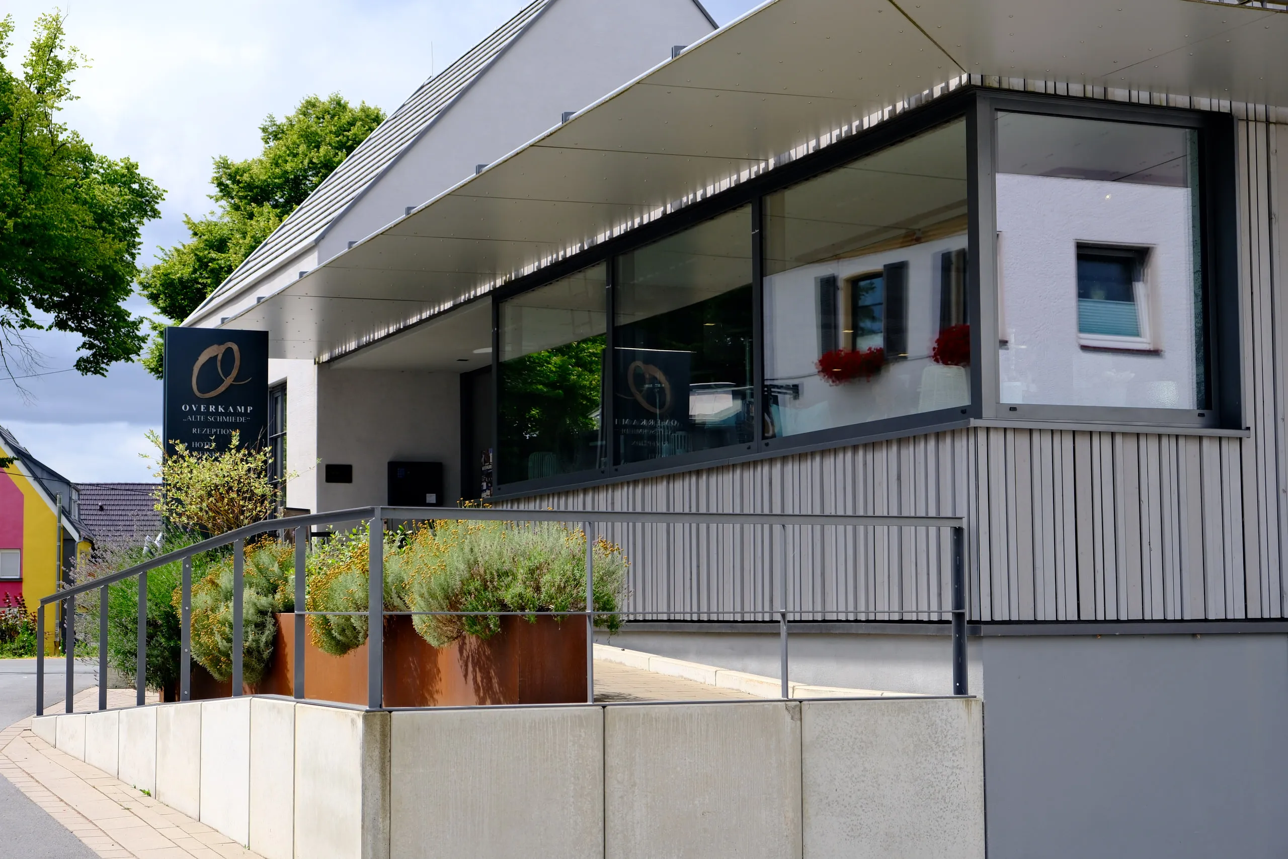 Hotel Overkamp mit Glasfront und bepflanzter Terrasse