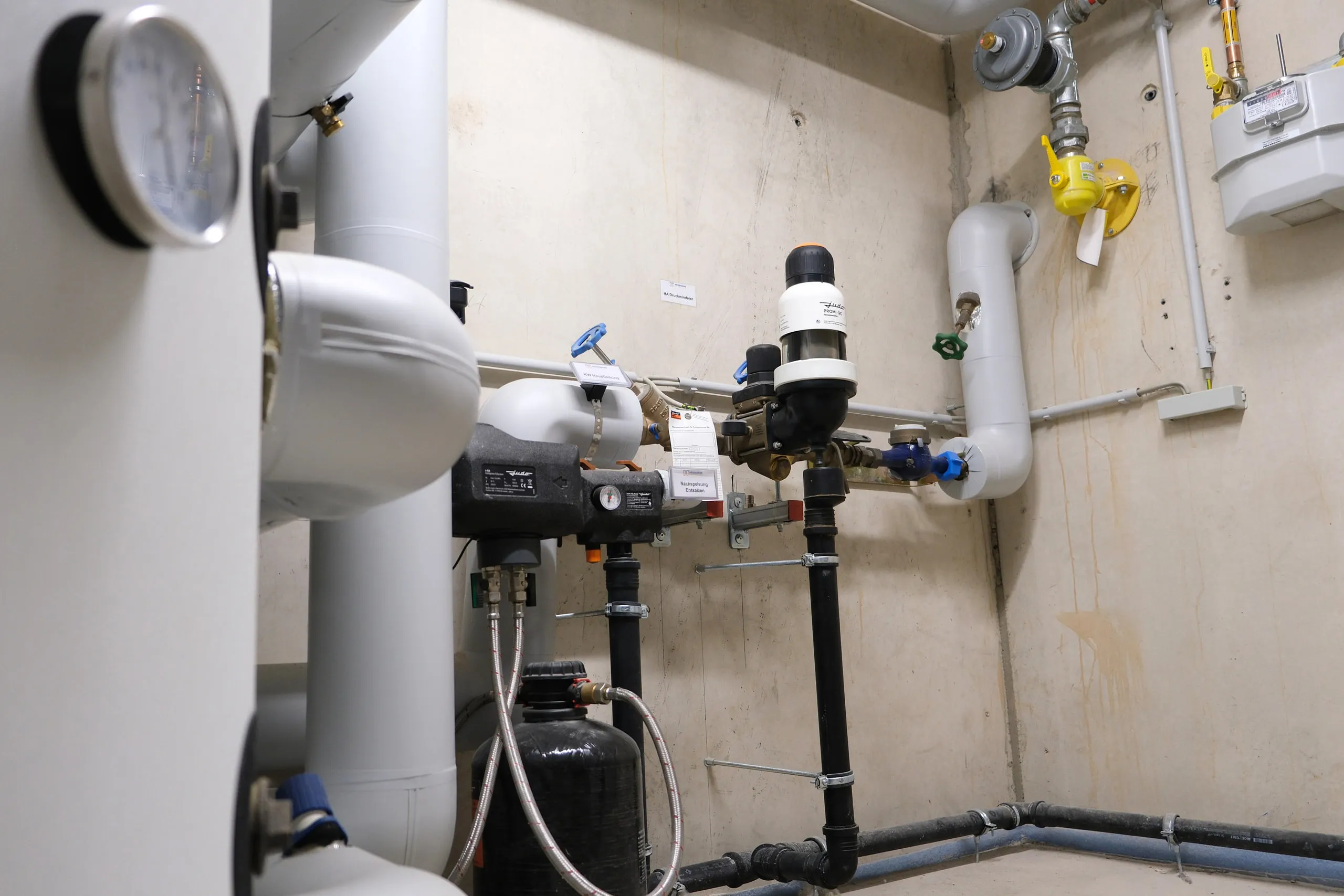 Gedämmte Rohrleitungen mit Pumpe und Armaturen im Technikraum