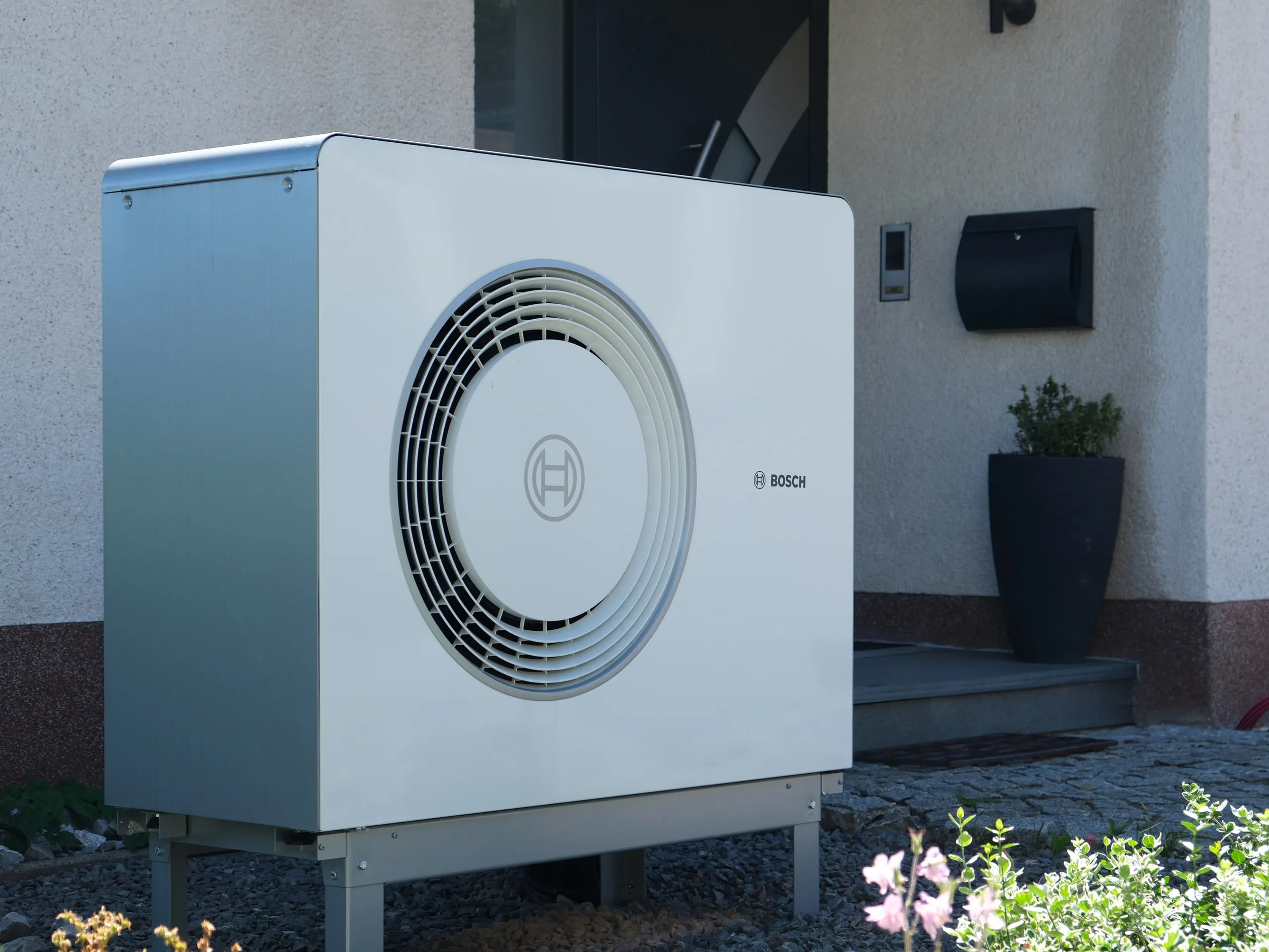 Außeneinheit einer Bosch-Wärmepumpe am Hauseingang eines Einfamilienhauses